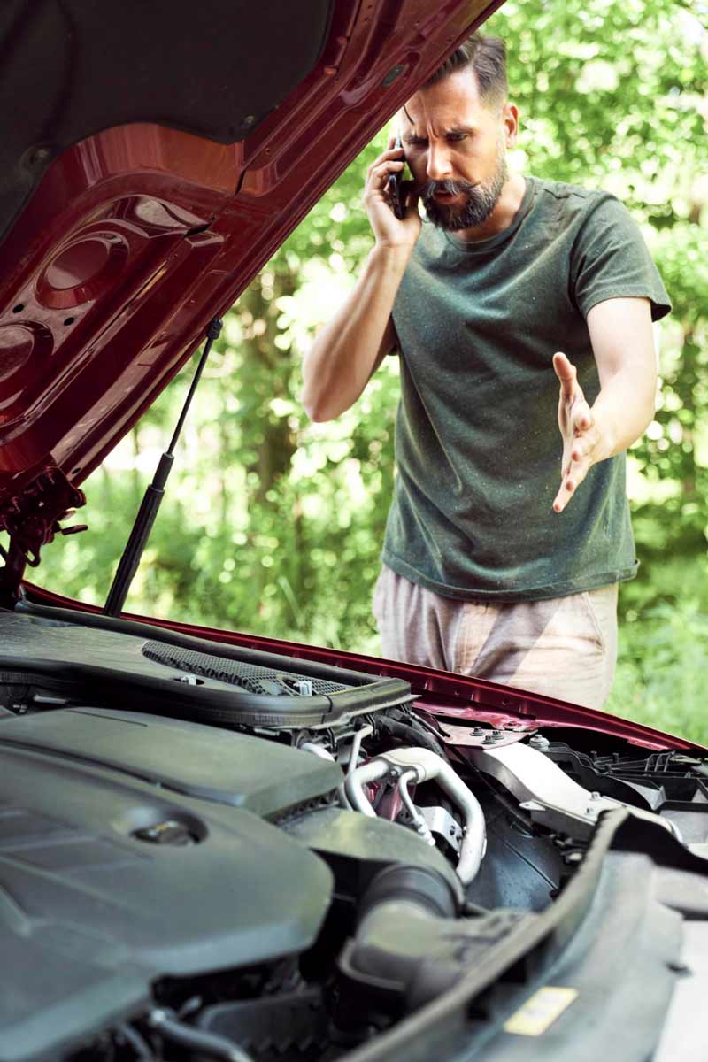 Junger Mann prüft Getriebeschaden bei Schrottauto Ankauf Espelkamp